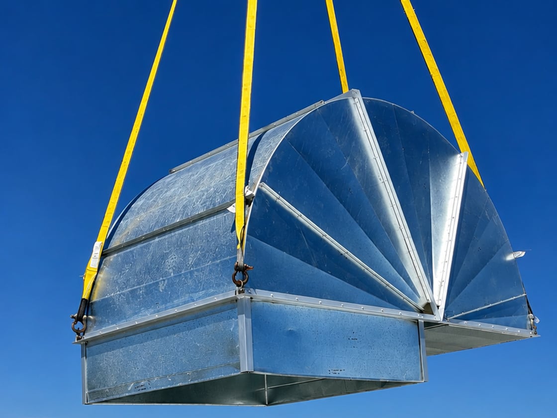 A galvanised gooseneck intake hood, fabricated in our own shop, being craned into place on a roof